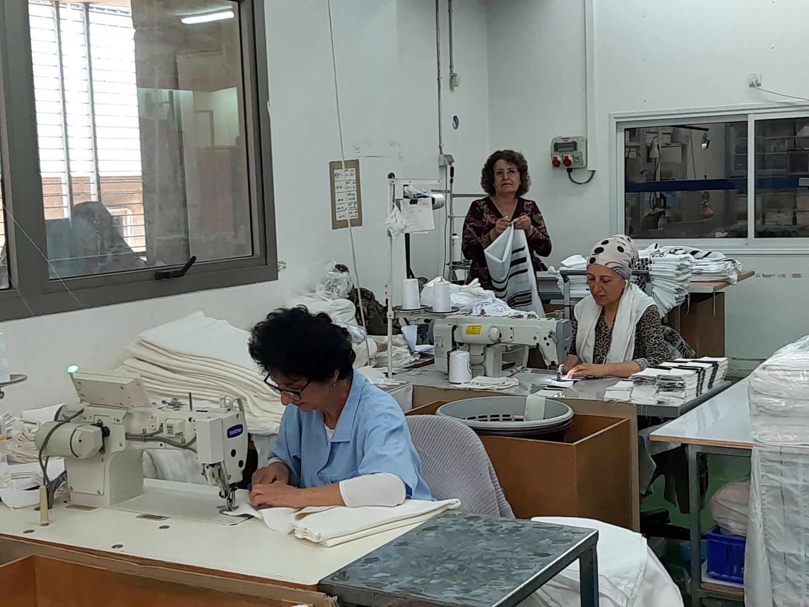 Artisans sewing by hand in our Holy Land workshop